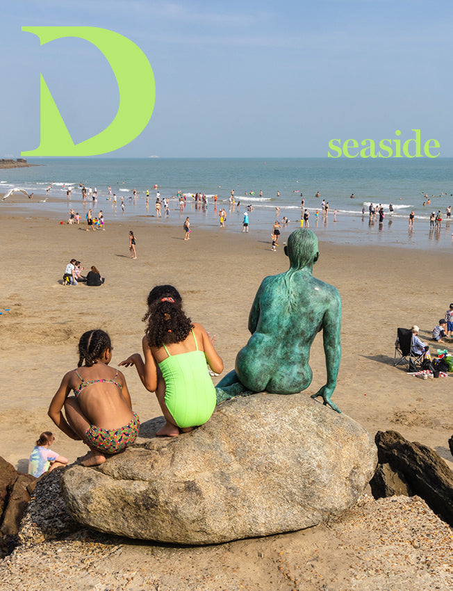 The beach in Folkestone with children playing and sculpture 