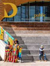 Load image into Gallery viewer, A building in London&#39;s Olympic Park, two young women pose for an unseen photograph in colourful outfits. To the right, an older person with cane sits on the wooden steps. 
